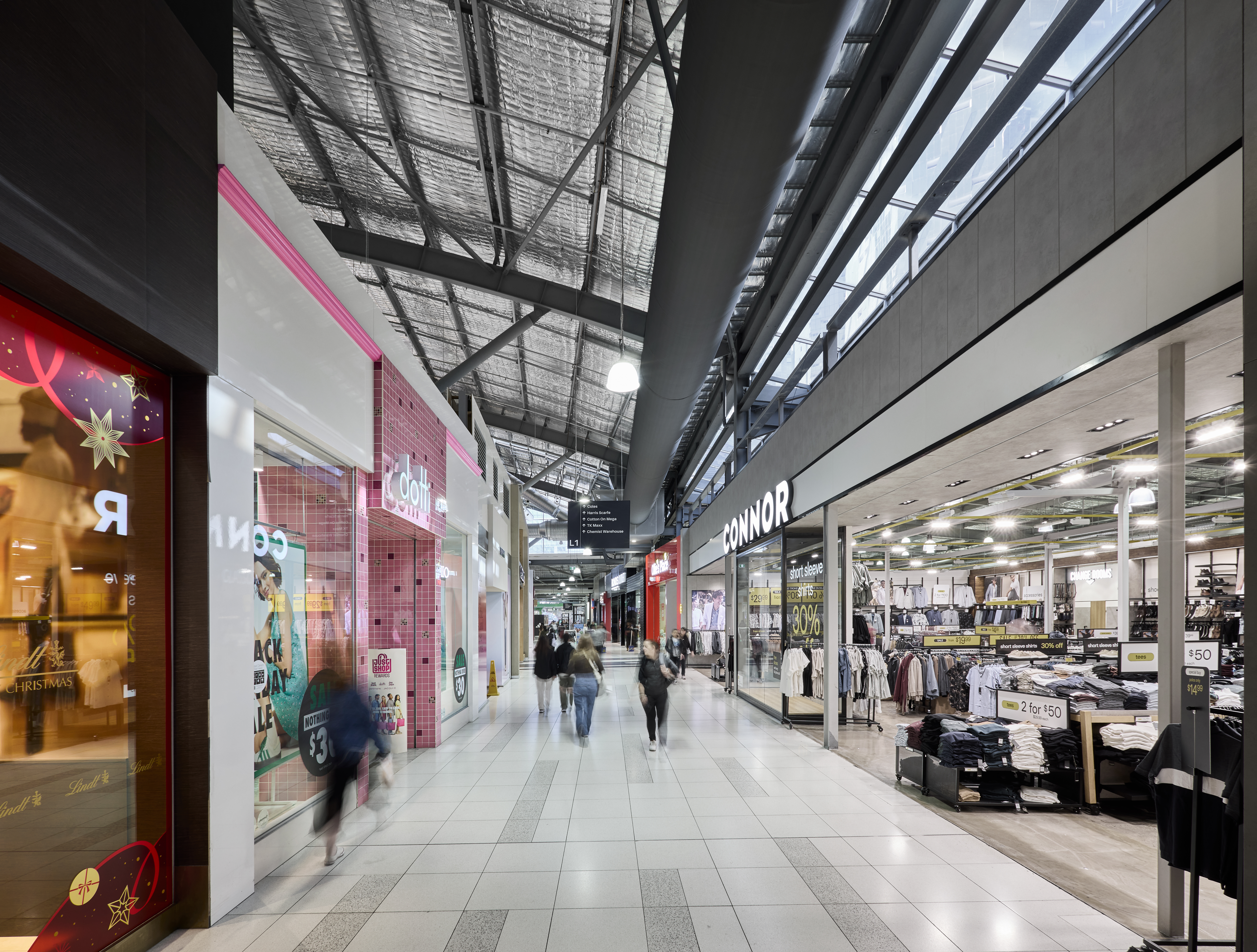 Completed main thoroughfare of Spencer Outlet Centre showing lowered ductwork and refurbished retail environment.